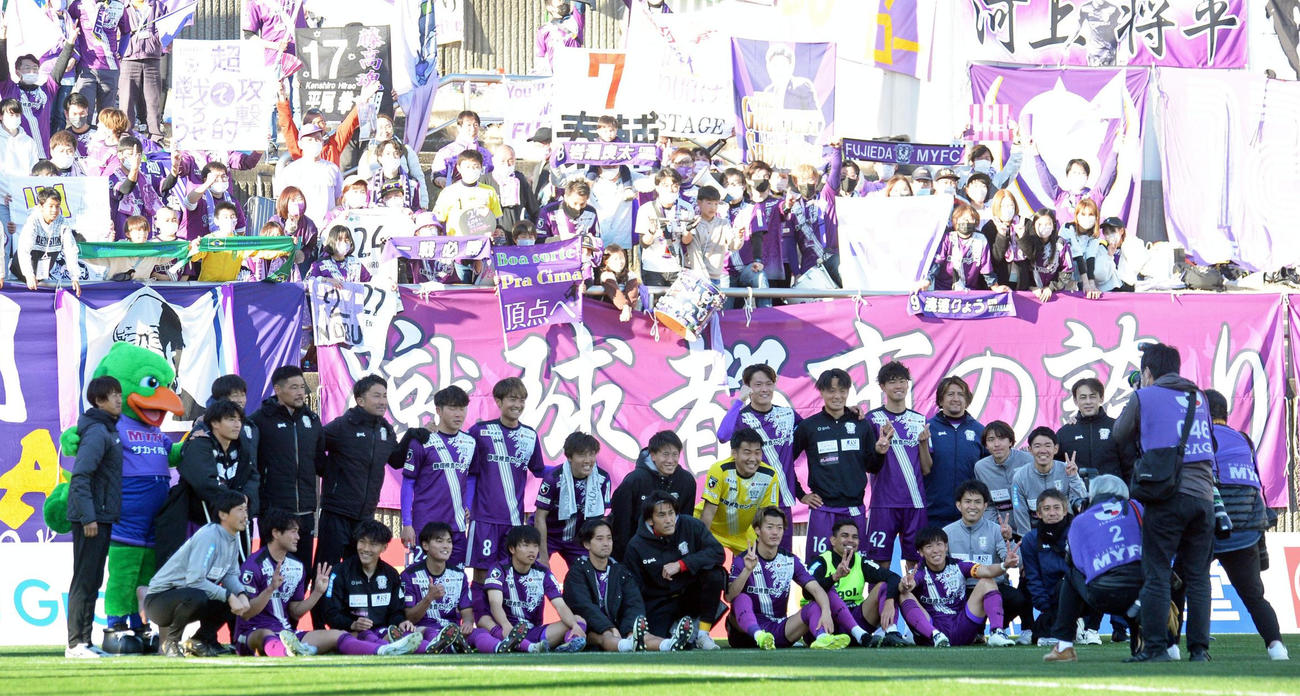 開幕2連勝を飾り、サポーターを背に記念撮影する藤枝の選手とスタッフら
