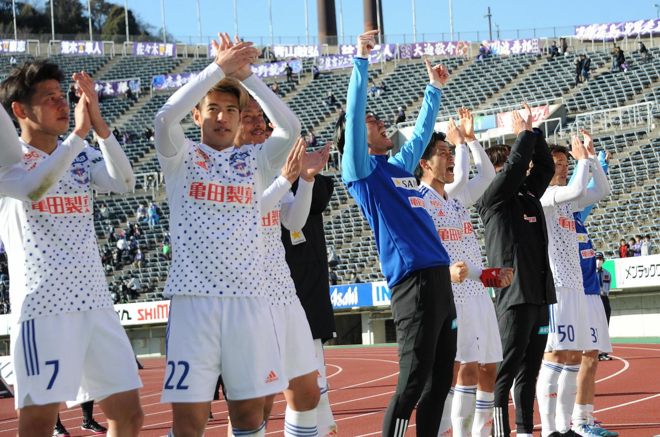 J1復帰後初勝利をつかみ、サポーターと喜び合う新潟の選手たち