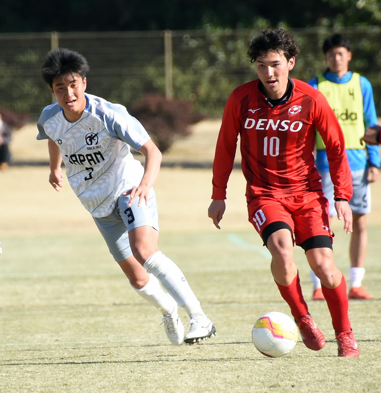 2月28日、明大でチームメートになる関東選抜A・MF佐藤（右）と対戦した日本高校選抜DF多久島