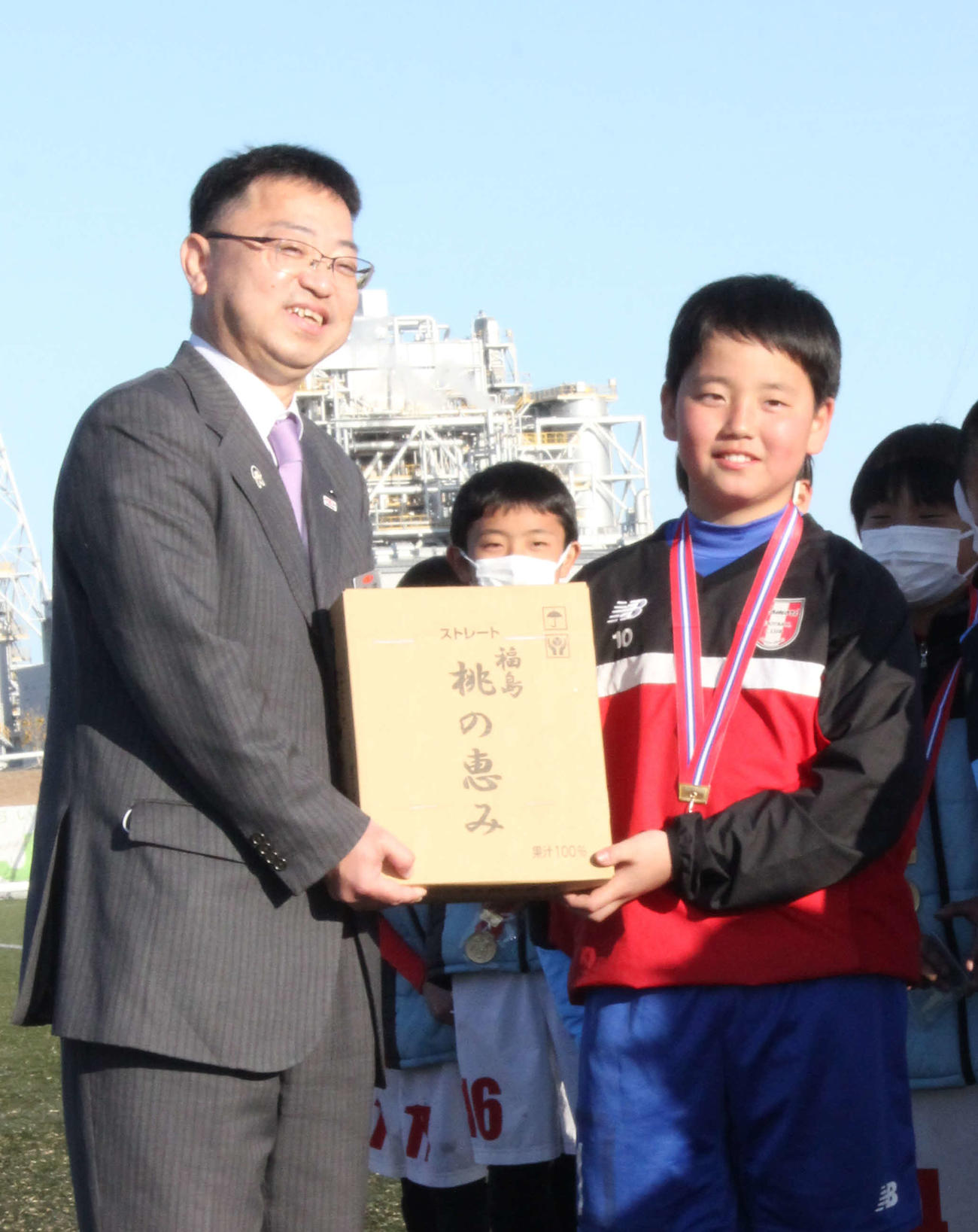 優勝チームに副賞を手渡す。JA全農福島の金成広之副本部長（左）