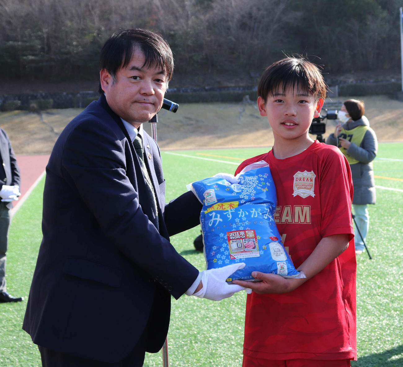 優勝チームに副賞を手渡したJA全農しがの浦山健副本部長（左）