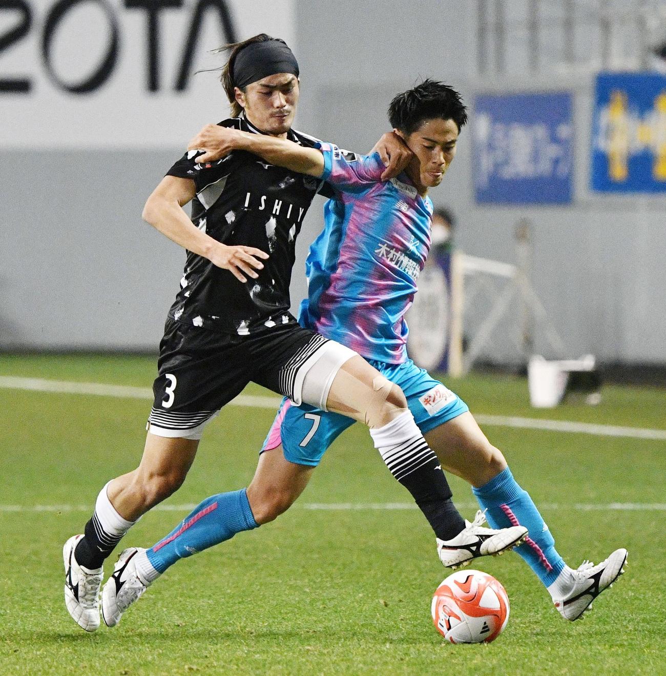 鳥栖対札幌　前半、競り合う札幌馬場（左）と鳥栖手塚（共同）