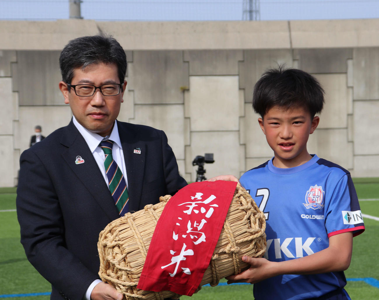 優勝チームに副賞を手渡すJA全農にいがたの高野洋副本部長（左）