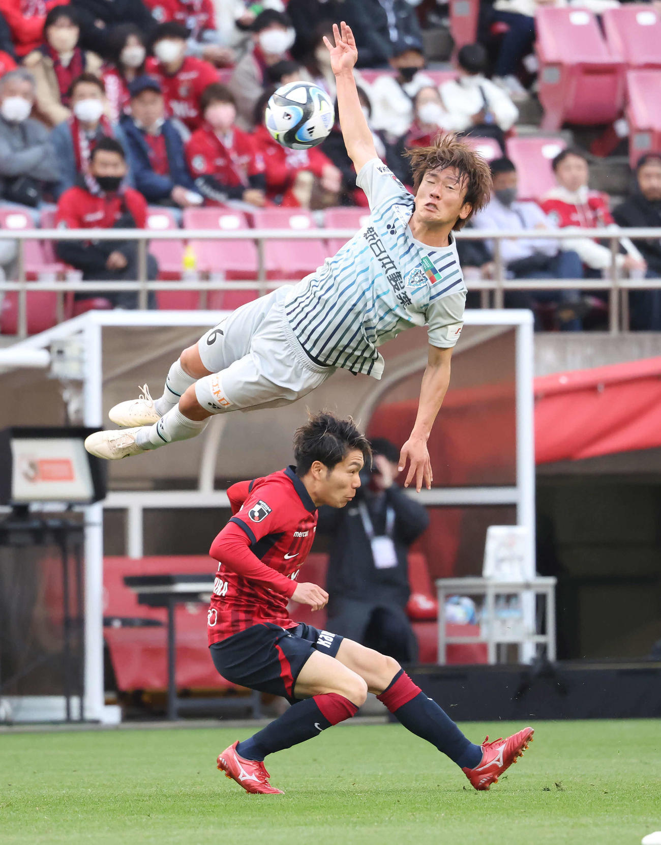 鹿島対福岡　後半、鹿島松村（下）と競り合って宙を舞う福岡小田（撮影・丹羽敏通）