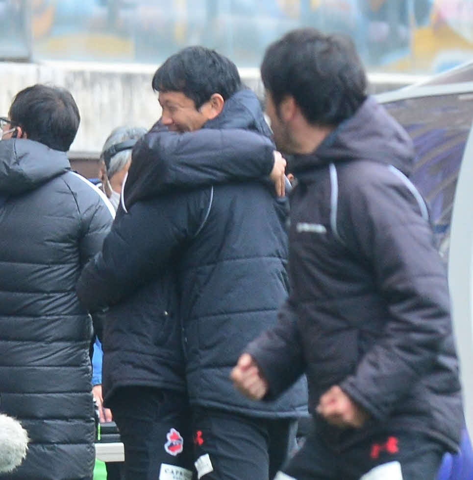 勝利の瞬間、スタッフと抱き合う村主監督（中央）