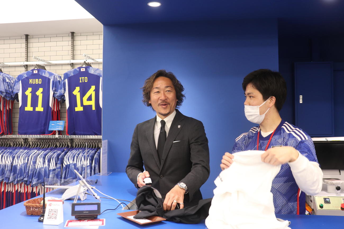 サッカーショップKAMO新宿店のレジで接客する石川直宏氏