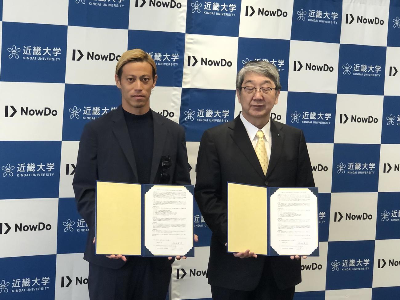 包括連携協定を締結し18日に記念撮影する近大の細井美彦学長（右）と本田圭佑（撮影・益子浩一）