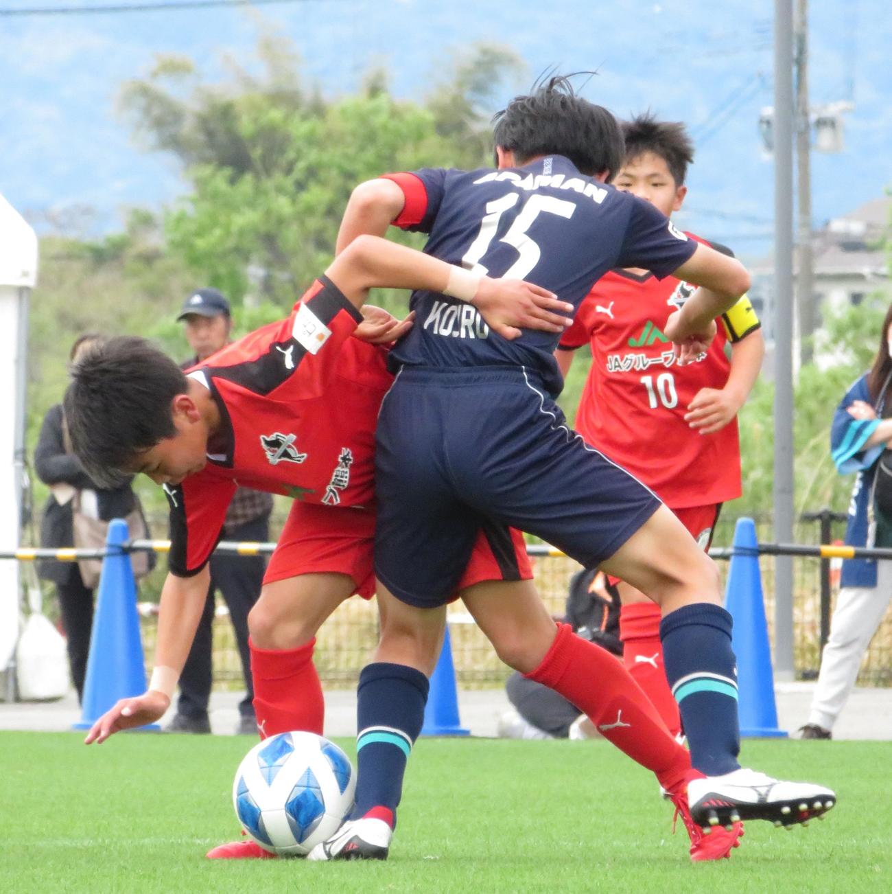 アビスパ福岡との準々決勝で、激しい攻防を繰り広げるロアッソ熊本ジュニアの選手（左）（撮影・峯岸佑樹）