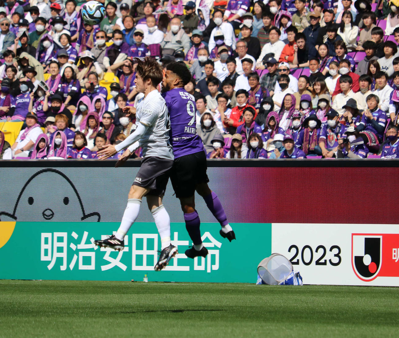 ヘディングで競り合う京都FWパトリック（右）と神戸DF酒井高徳（撮影・益子浩一）