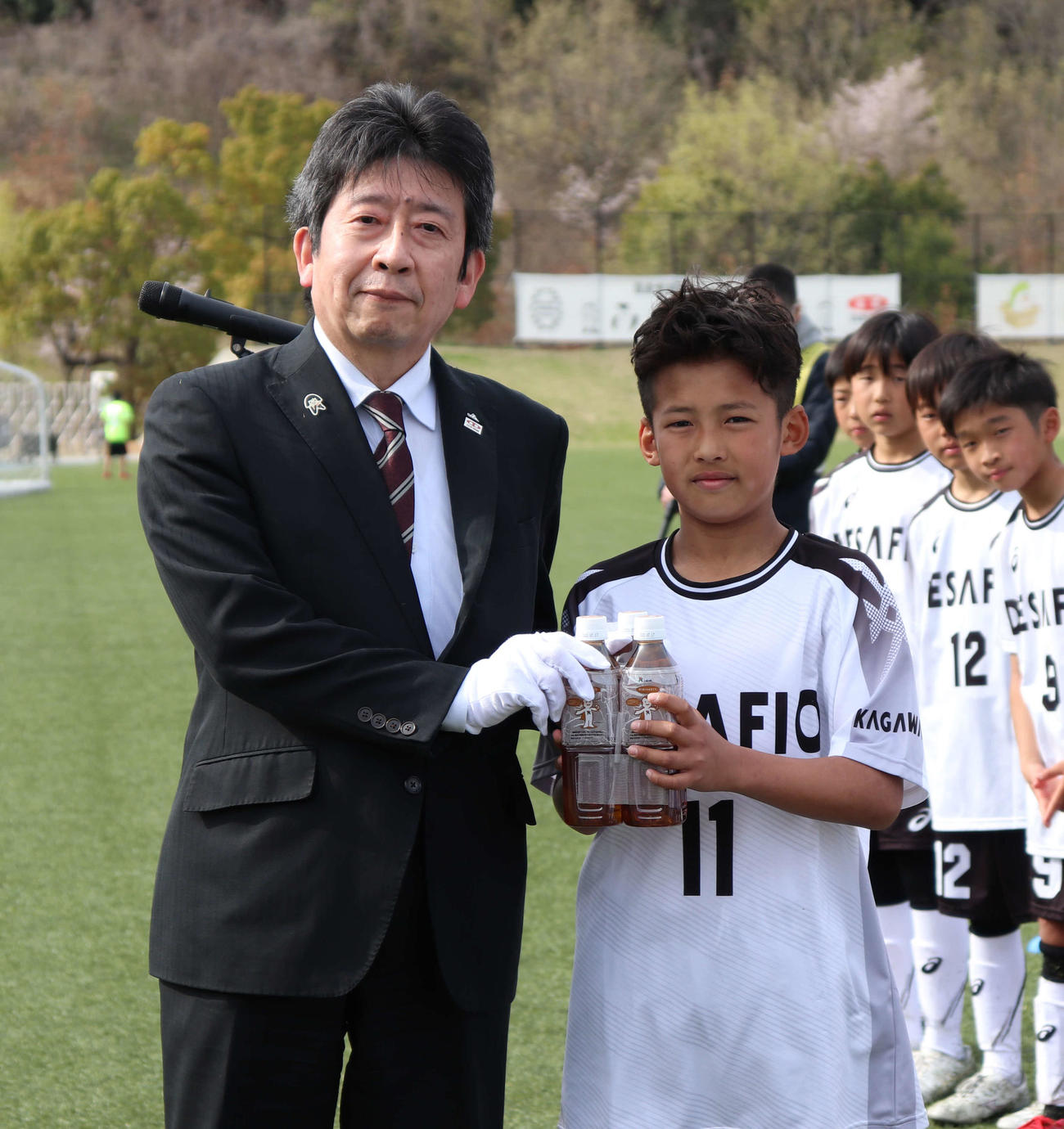 優勝チームに副賞を手渡すJA全農広報・調査部の新妻成一部長（左）