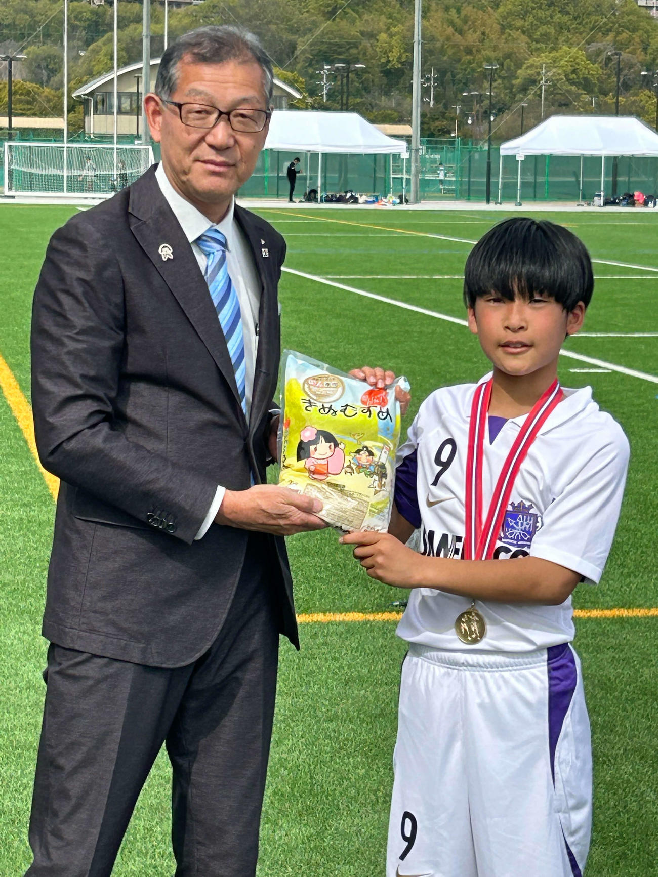 優勝チームに副賞を手渡すJA全農おかやま伍賀弘県本部長（左）