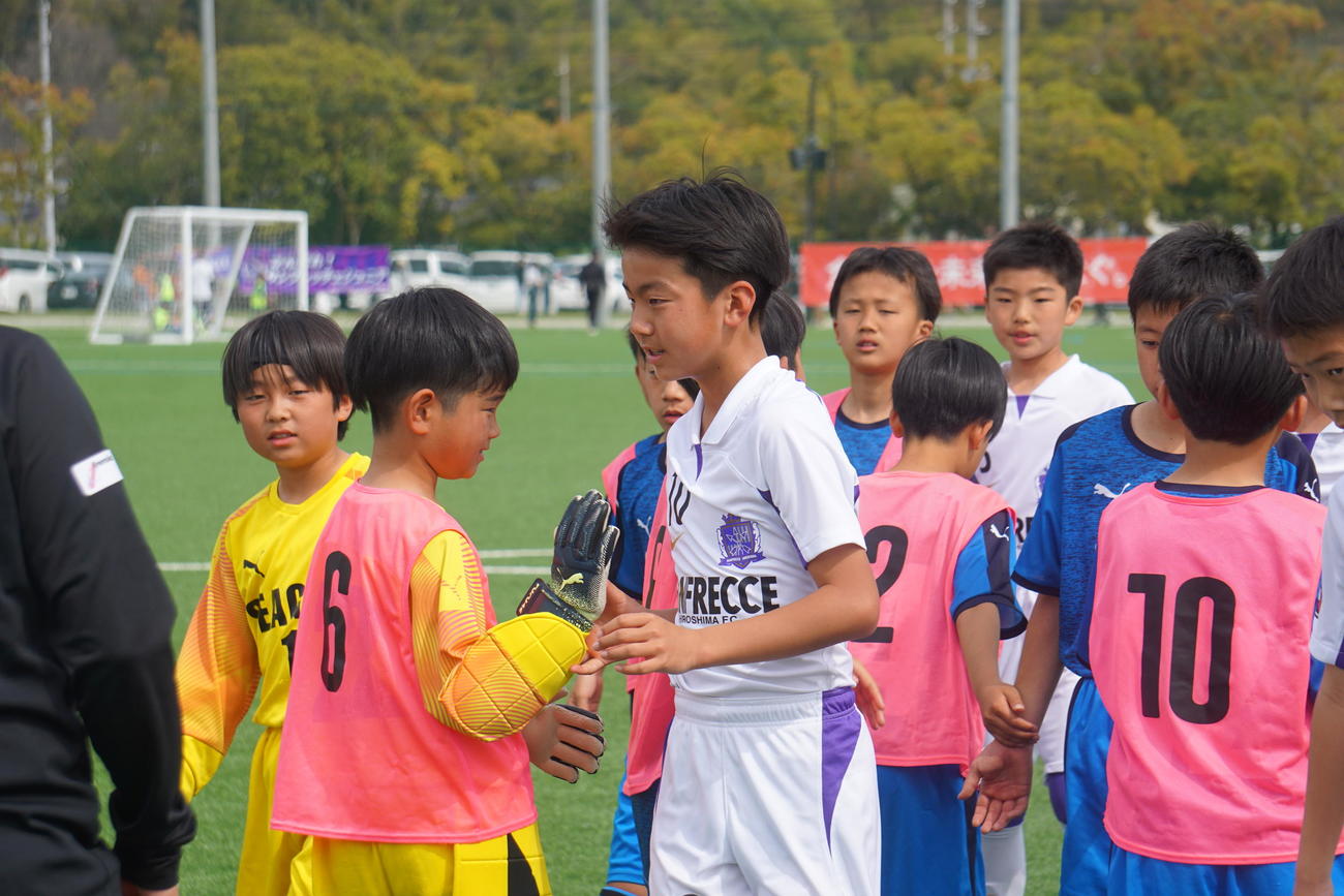 決勝を終え健闘をたたえ合うサンフレッチェ坂藤龍之介（中央）ら両チームの選手