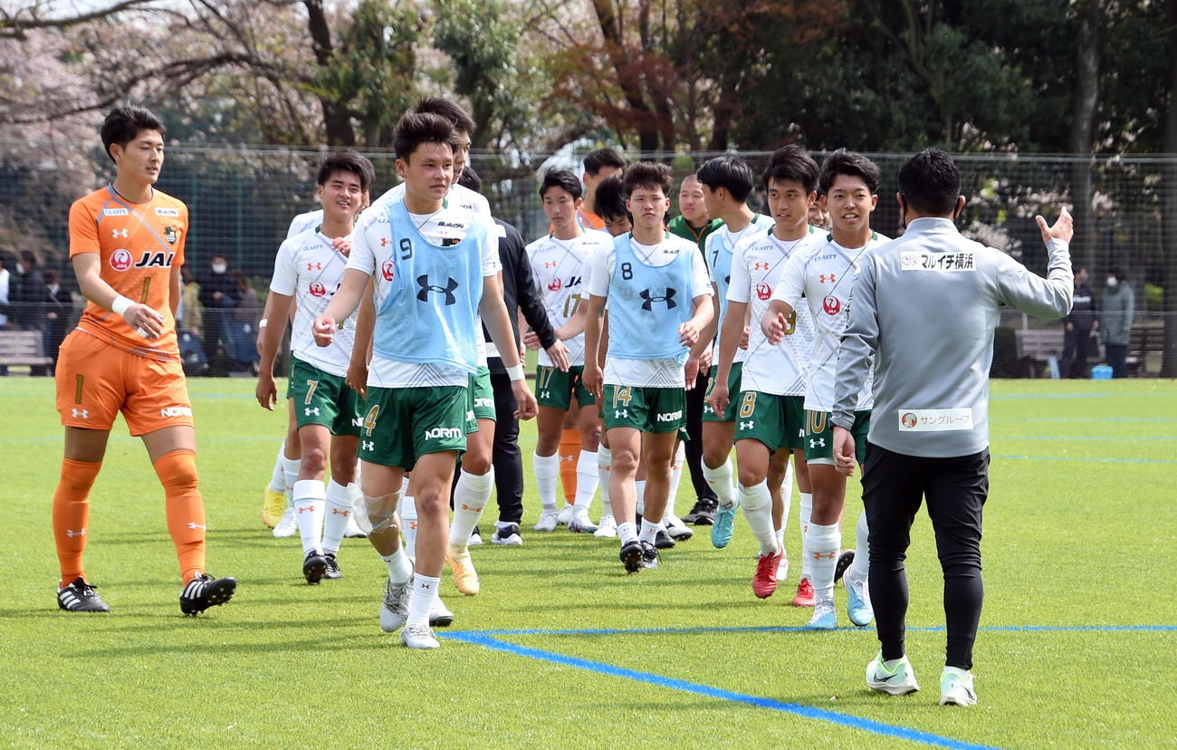 開幕戦に勝利した選手たちを出迎える正木監督（右）