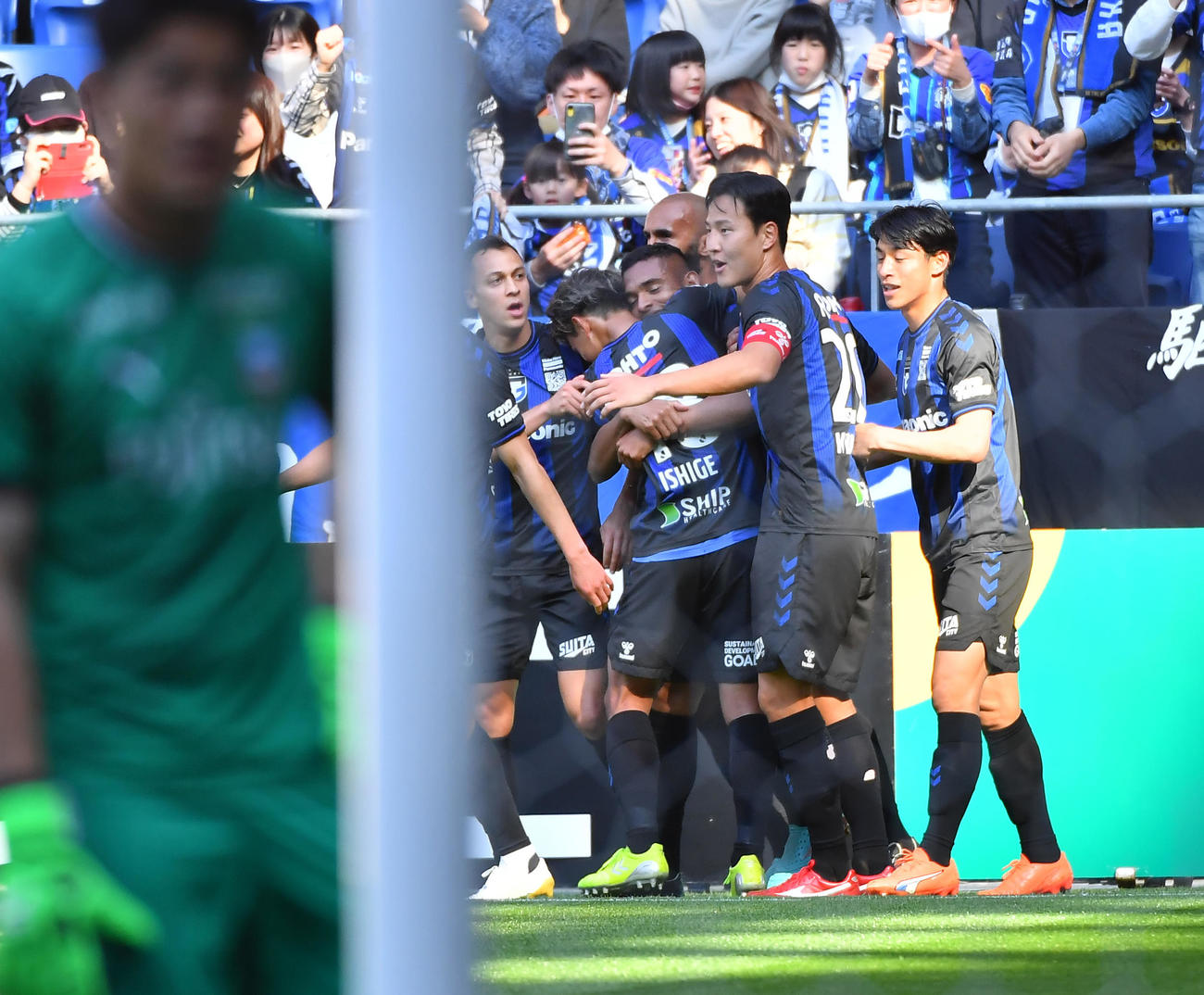 G大阪対川崎F　前半、先制ゴールを決めたG大阪ダワン（中央）が石毛らから祝福を受ける（撮影・清水貴仁）