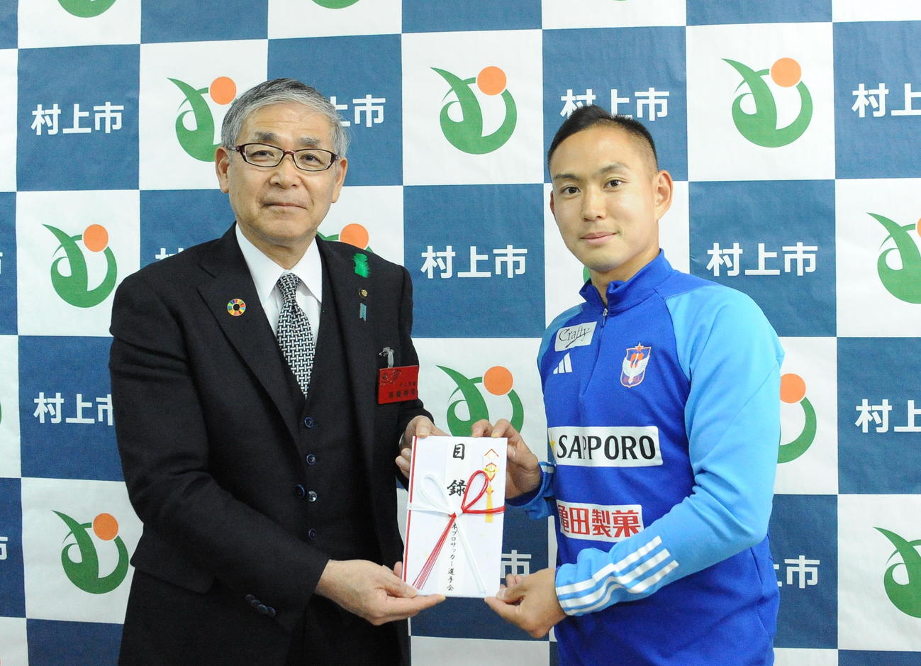 高橋村上市長（左）に日本プロサッカー選手会からの災害義援金を寄付する早川