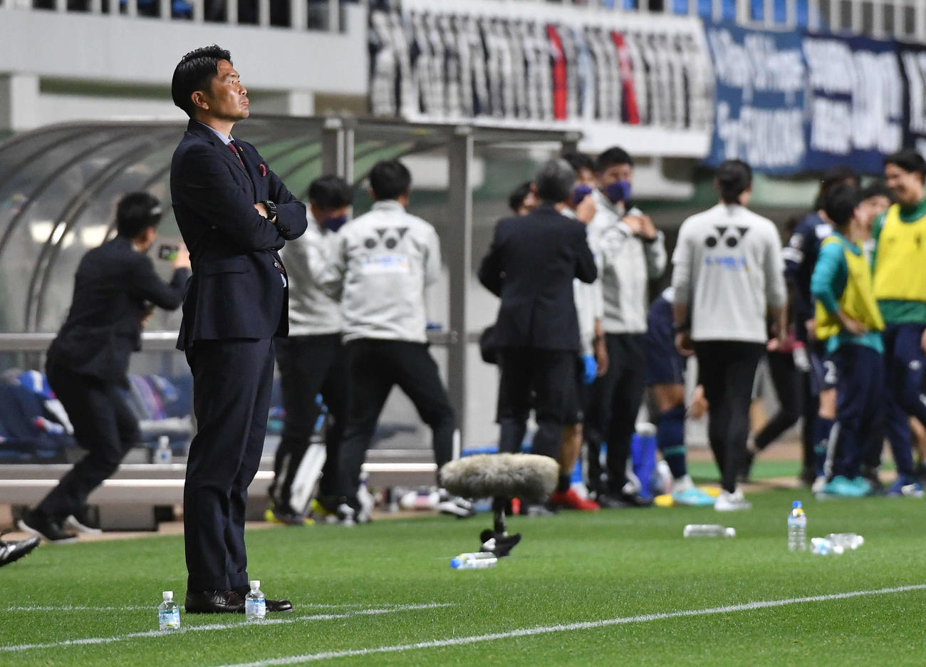 ルヴァン杯　福岡対鹿島　勝利し喜ぶ福岡イレブンの手前で、腕を組み厳しい表情を見せる鹿島岩政監督（撮影・岩下翔太）