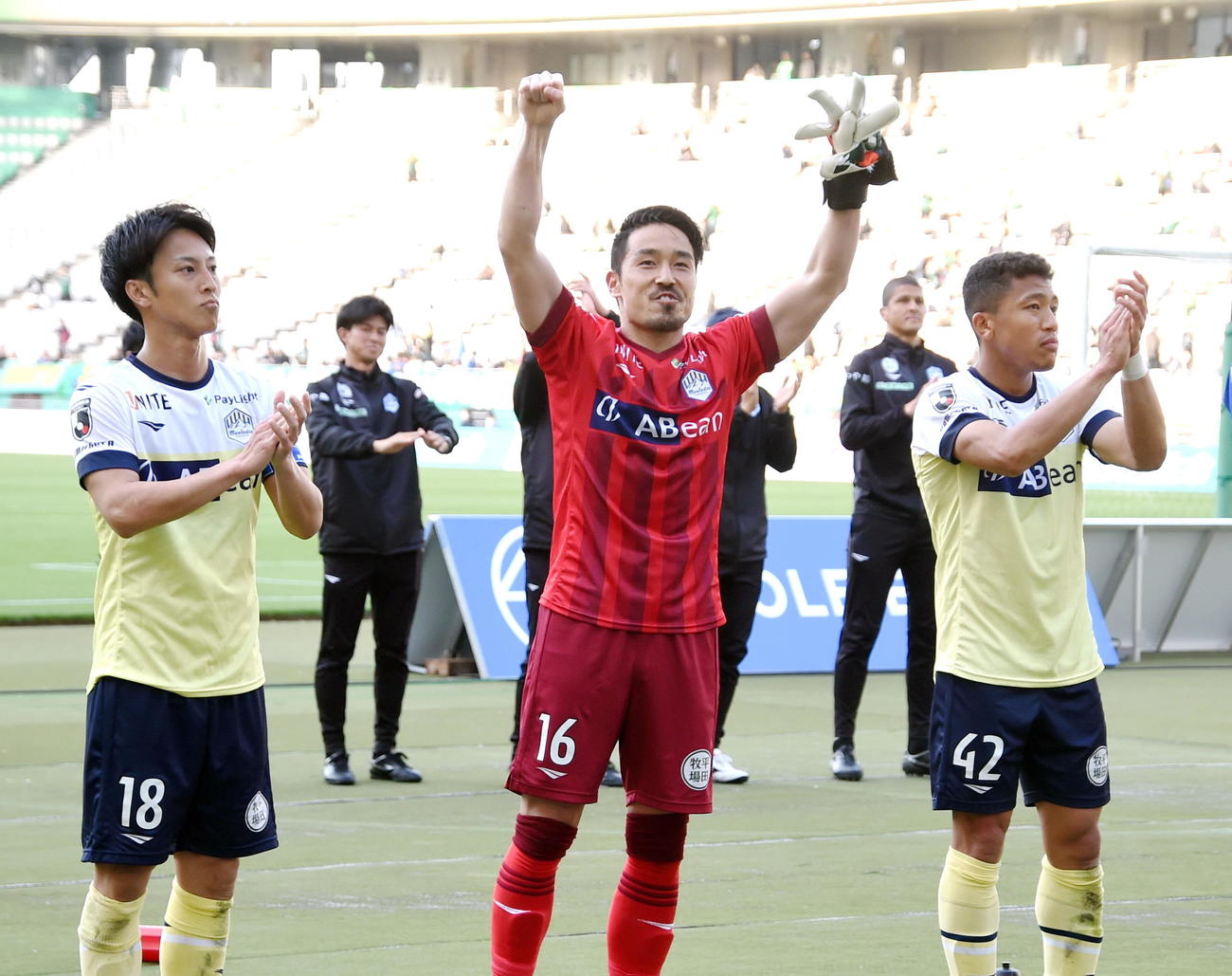初出場初先発で勝利に貢献しサポーターと喜びを分かち合う山形GK長谷川（中央）。左はMF南、右はFWイサカ（撮影・山田愛斗）