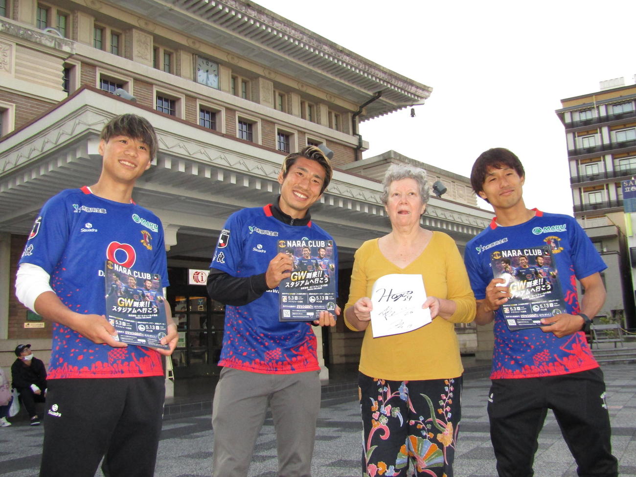 J3奈良の告知活動に参加したMF片岡爽（右）、FW浅川隼人（左から2人目）、FW酒井達磨（左）はフランスから観光に来た女性にPRする
