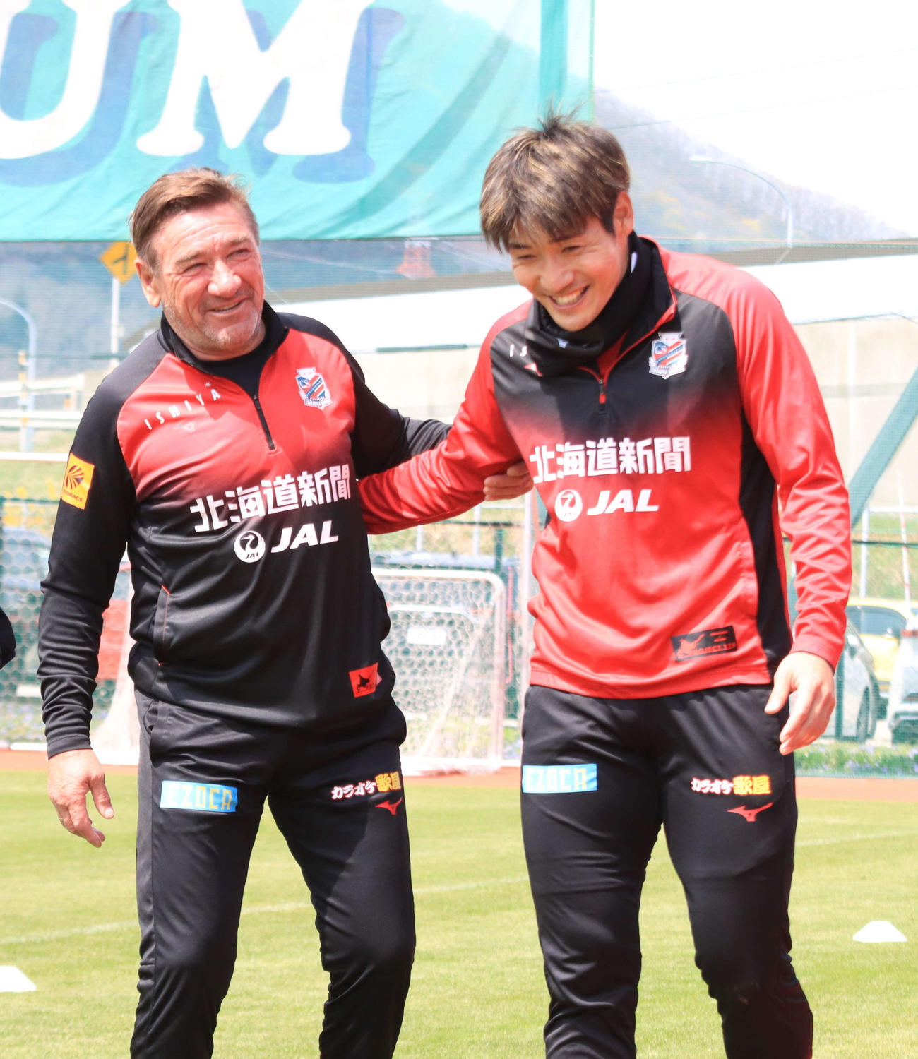 練習を終え、笑顔でクラブハウスに戻る札幌ペトロビッチ監督（左）と岡村（撮影・保坂果那）