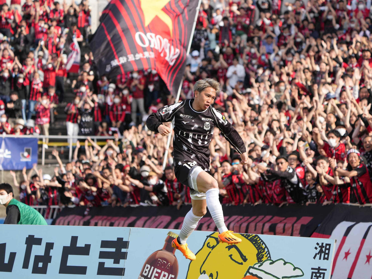 横浜FC対札幌　後半、札幌浅野（中央）はこの日2点目のゴールを奪い詰め掛けた大勢のサポーターの前で歓喜のガッツポーズ（撮影・小沢裕）