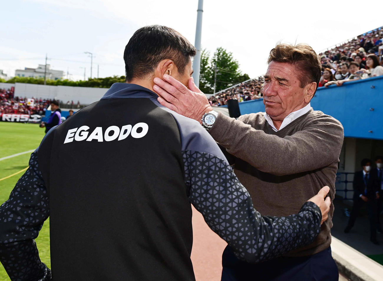 横浜FC対札幌　試合前に互いの健闘をたたえ合う札幌ペトロヴィッチ監督（右）と横浜FC四方田監督（撮影・小沢裕）