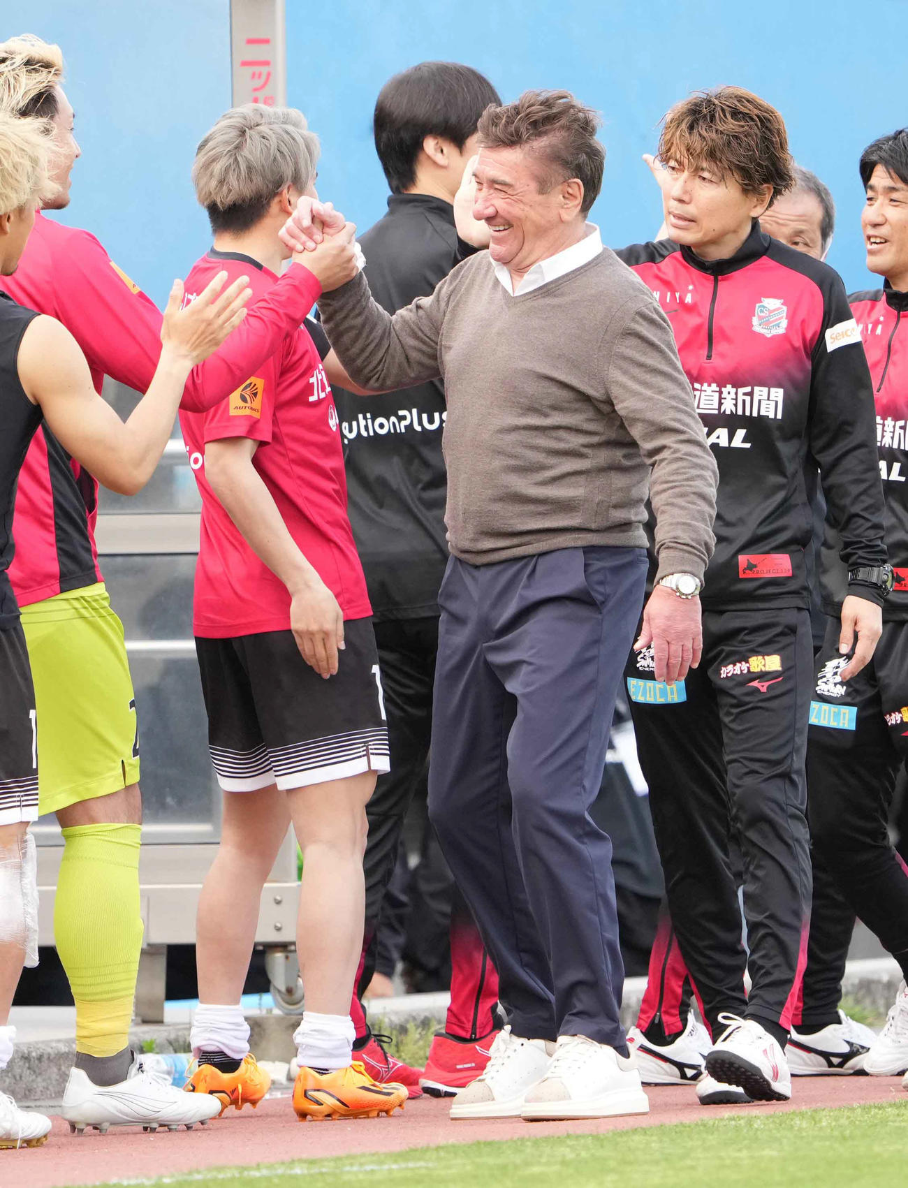 横浜FC対札幌　4ゴールを奪っての快勝にスタッフと笑顔でハイタッチする札幌ペトロヴィッチ監督（撮影・小沢裕）