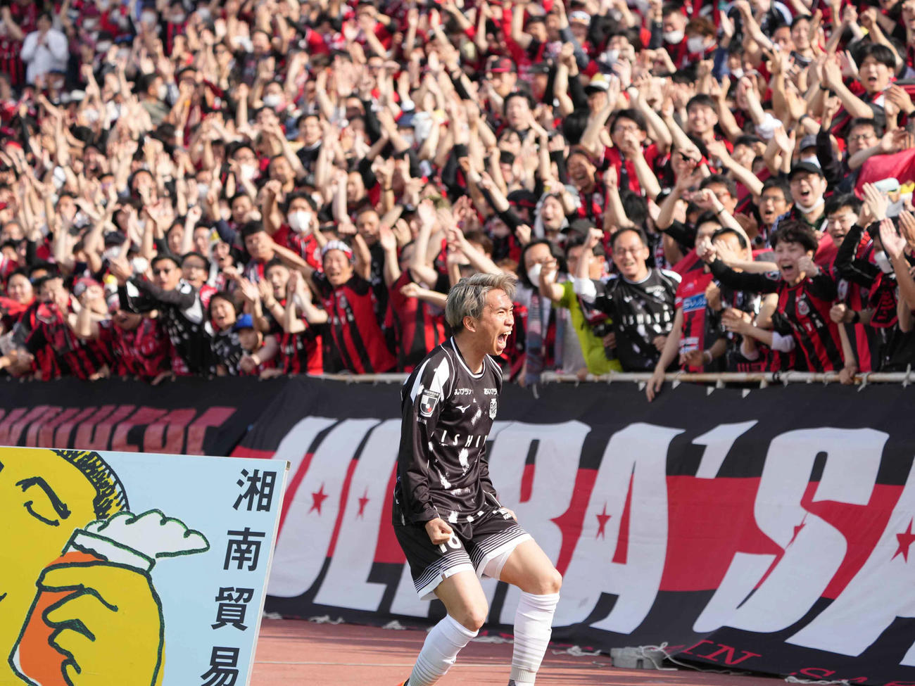 横浜FC対札幌　後半、札幌浅野（中央）はこの日2点目のゴールを奪い詰め掛けた大勢のサポーターの前で雄たけびを上げる（撮影・小沢裕）