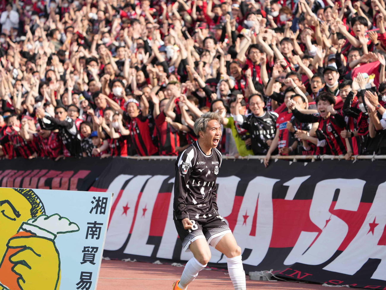 横浜FC対札幌　後半、札幌浅野（中央）はこの日2点目のゴールを奪い詰め掛けた大勢のサポーターの前で雄たけびを上げる（撮影・小沢裕）
