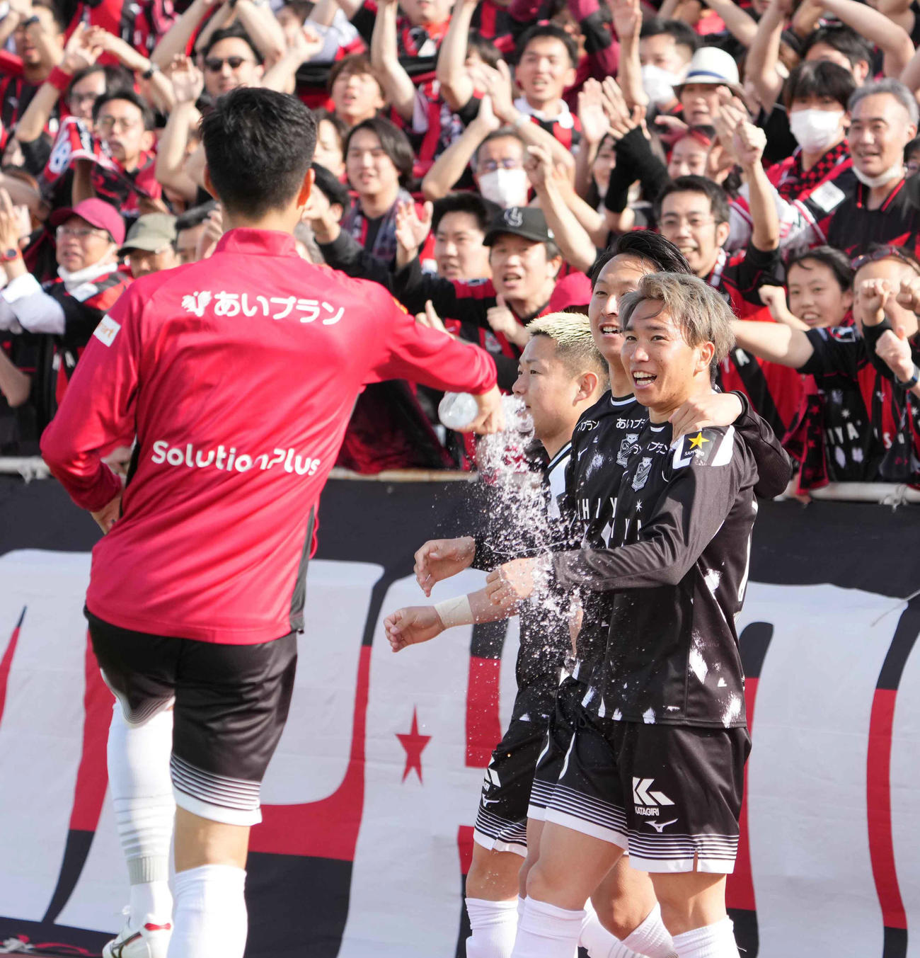 横浜FC対札幌　後半、札幌浅野（右）はこの日2点目のゴールを奪いイレブンの祝福を受ける（撮影・小沢裕）