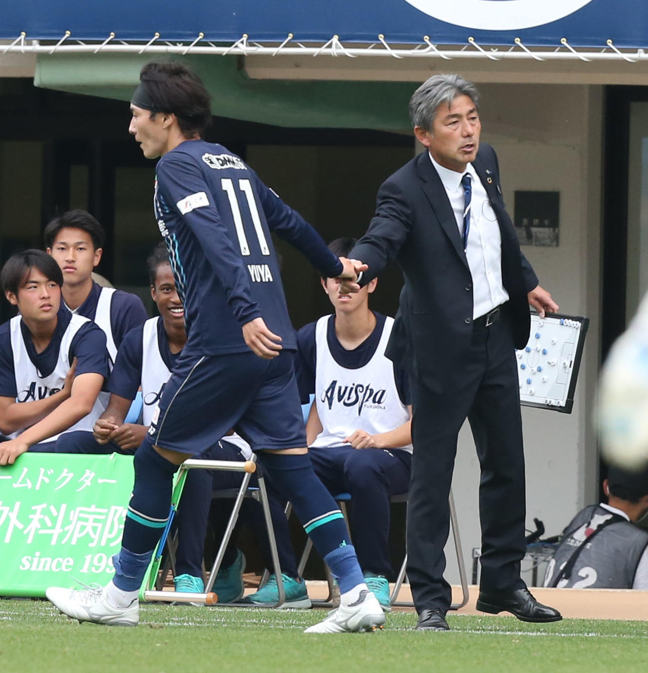 福岡対東京　後半、先制ゴールを決めた山岸は長谷部監督(右)と握手を交わす（撮影・冨田成美）