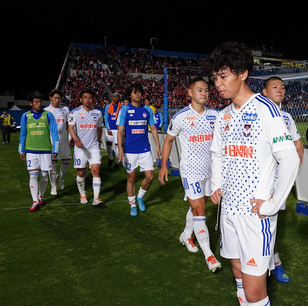 横浜FC対新潟　試合後、厳しい表情でサポーターの前に立つ新潟伊藤（右端）（撮影・江口和貴）