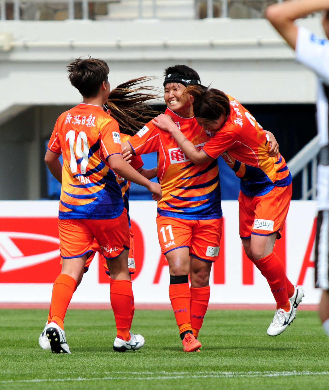 3試合連続ゴールを決め、チームメートから祝福を受ける新潟・道上（中央）