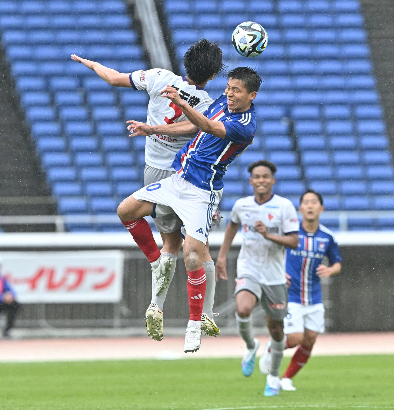 横浜対京都　後半、ヘディングで競り合う横浜西村（手前右）と京都麻田（撮影・滝沢徹郎）