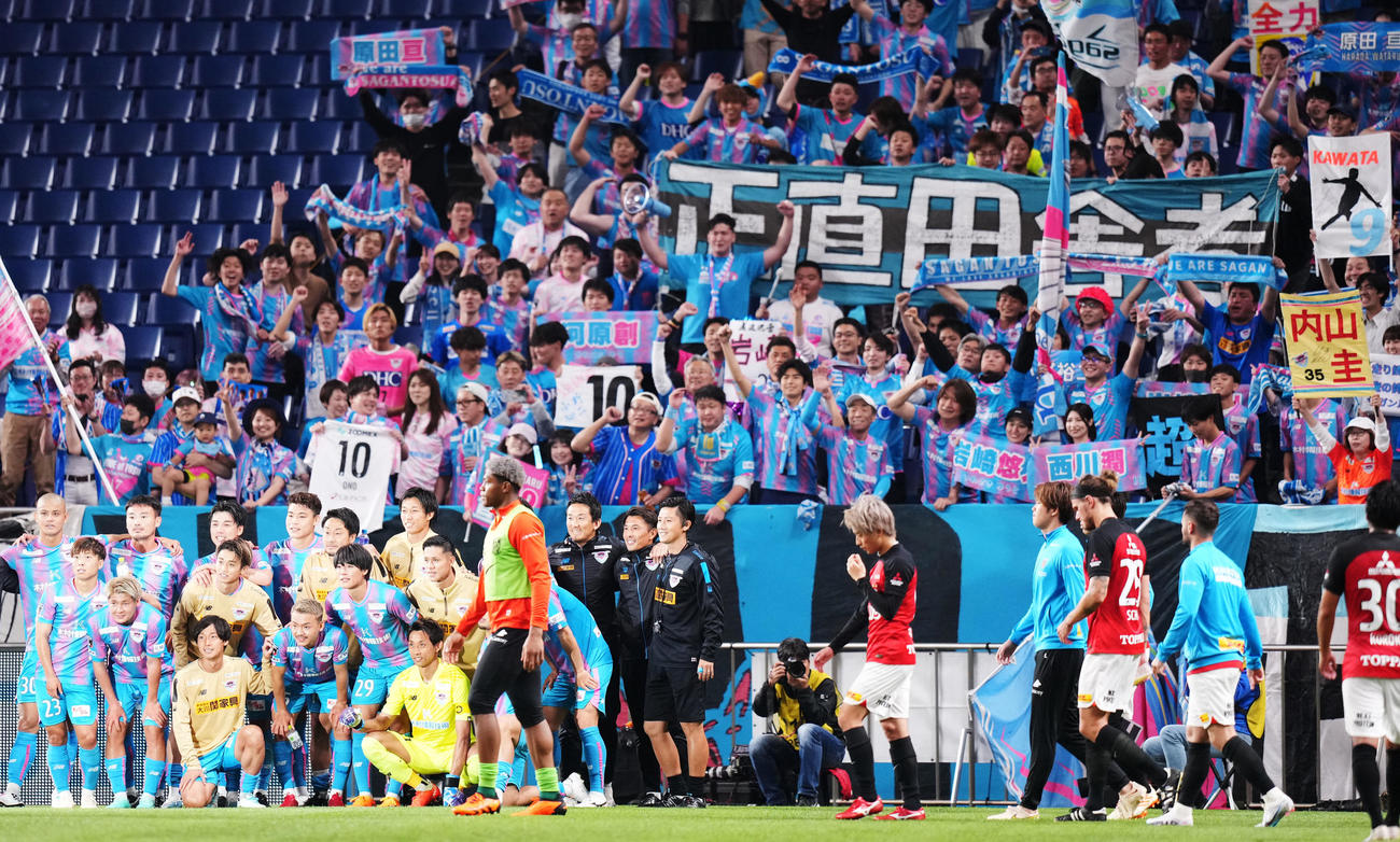 浦和対鳥栖　試合後、笑顔で集合写真を撮影する鳥栖イレブンの前を肩を落とし歩く浦和イレブン（撮影・横山健太）