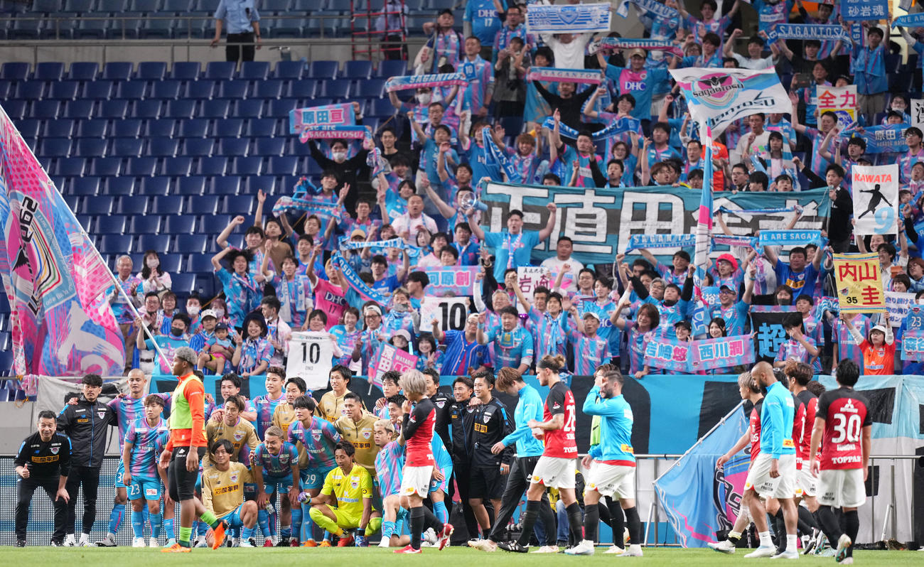 浦和対鳥栖　試合後、笑顔で集合写真を撮影する鳥栖イレブンの前を肩を落とし歩く浦和イレブン（撮影・横山健太）