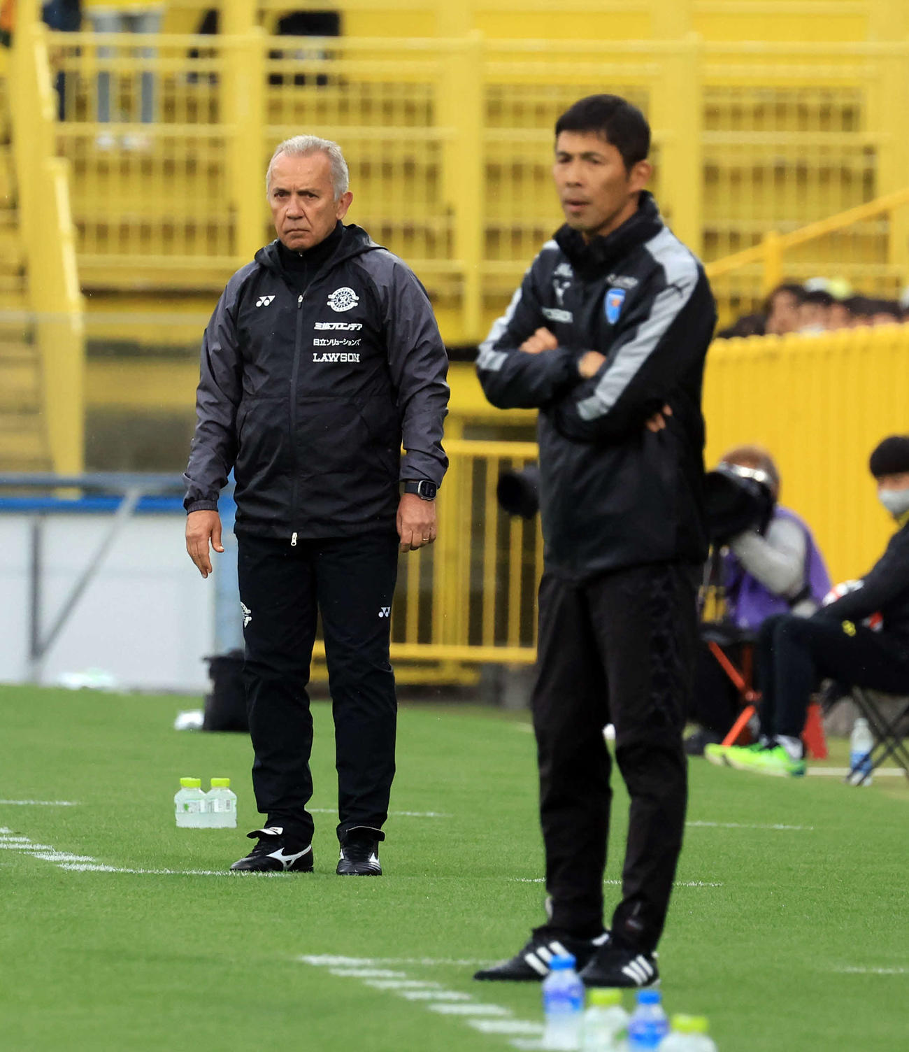 柏対横浜FC　前半、厳しい表情で試合を見つめる柏ネルシーニョ監督（奥）と横浜FC四方田監督（撮影・浅見桂子）