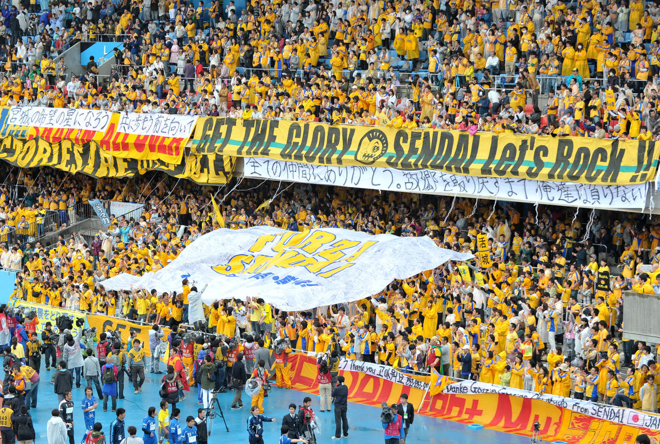 川崎F対仙台　川崎Fサポーターから届けられたフラッグを掲げる仙台サポーター（2011年4月23日撮影・下田雄一）