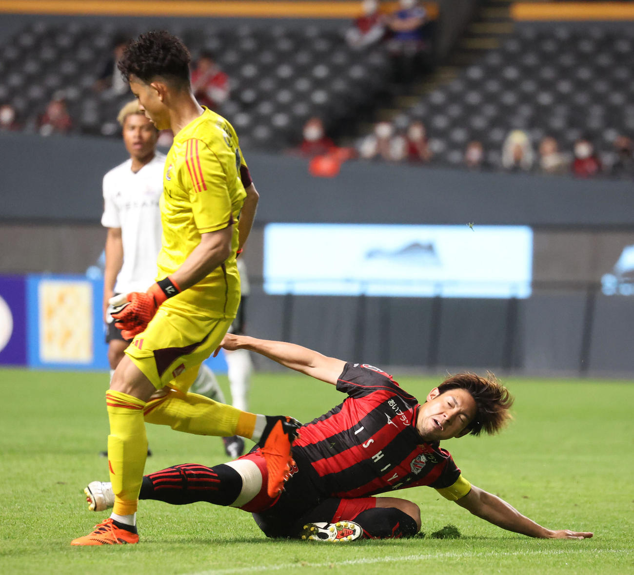 札幌対横浜　前半、足がぶつかってしまう横浜飯倉（左）と札幌深井（撮影・佐藤翔太）
