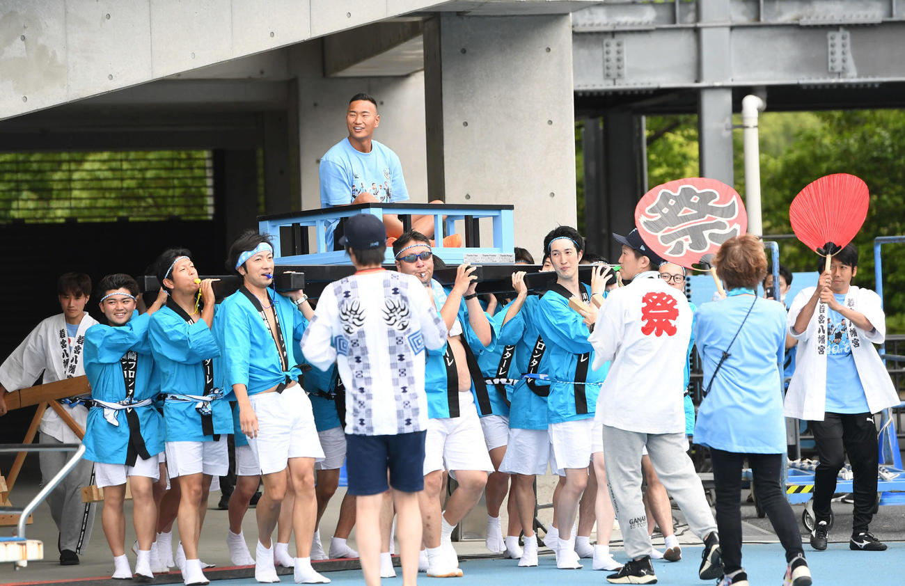 川崎F対柏　開始前、みこしに乗って引退式へ向かう鄭大世氏。右は盛り上げる中村憲剛氏（撮影・山崎安昭）