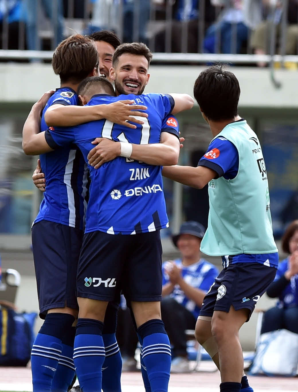 後半、山形アウベス（中央）は、2点目のゴールを決めたイサカ（手前）らと抱き合って喜ぶ（撮影・相沢孔志）