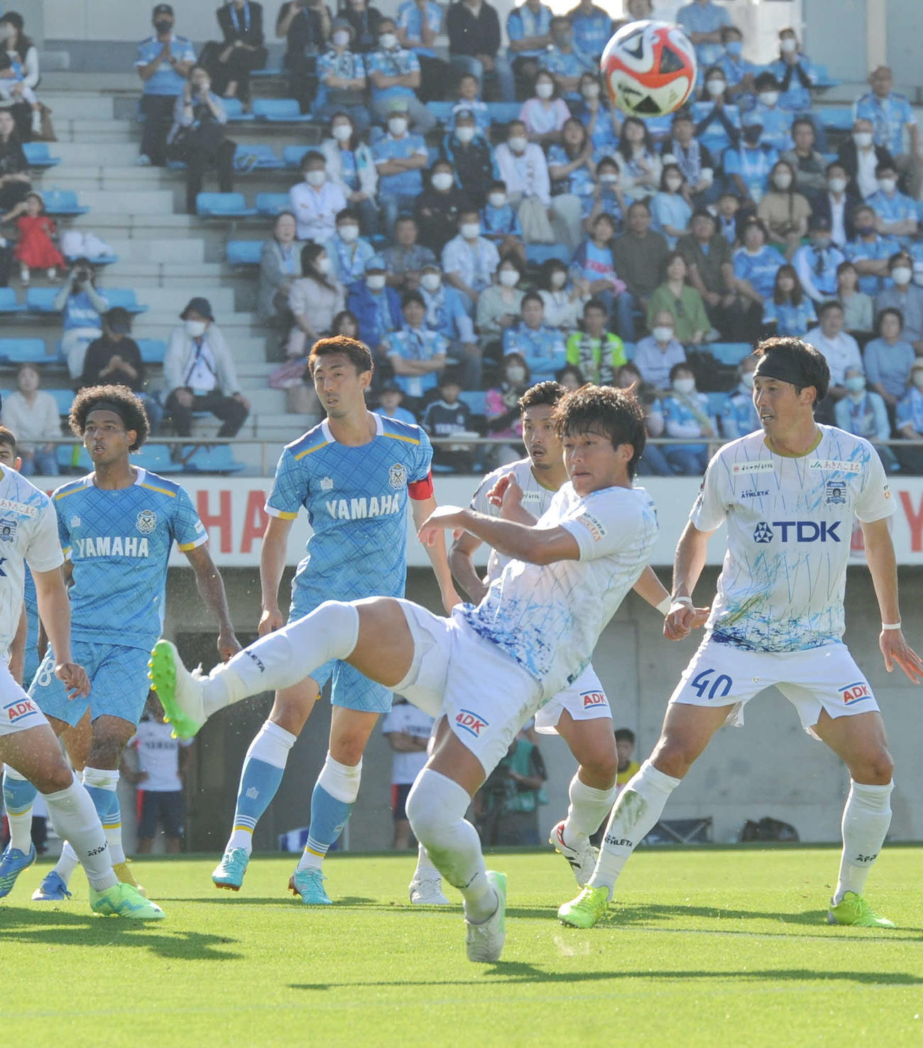 前半24分、相手CKをクリアする秋田DF阿部（中央）