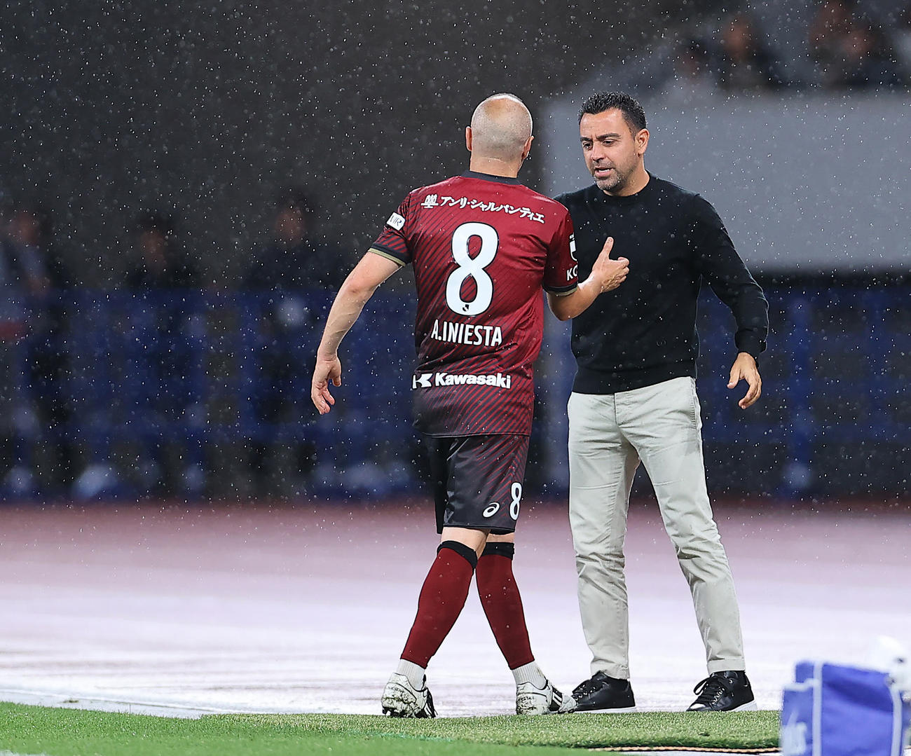 神戸対バルセロナ　後半、ピッチサイドまで途中交代でベンチに下がる神戸イニエスタ（左）を出迎え声をかけるバルセロナのシャビ監督（撮影・垰建太）