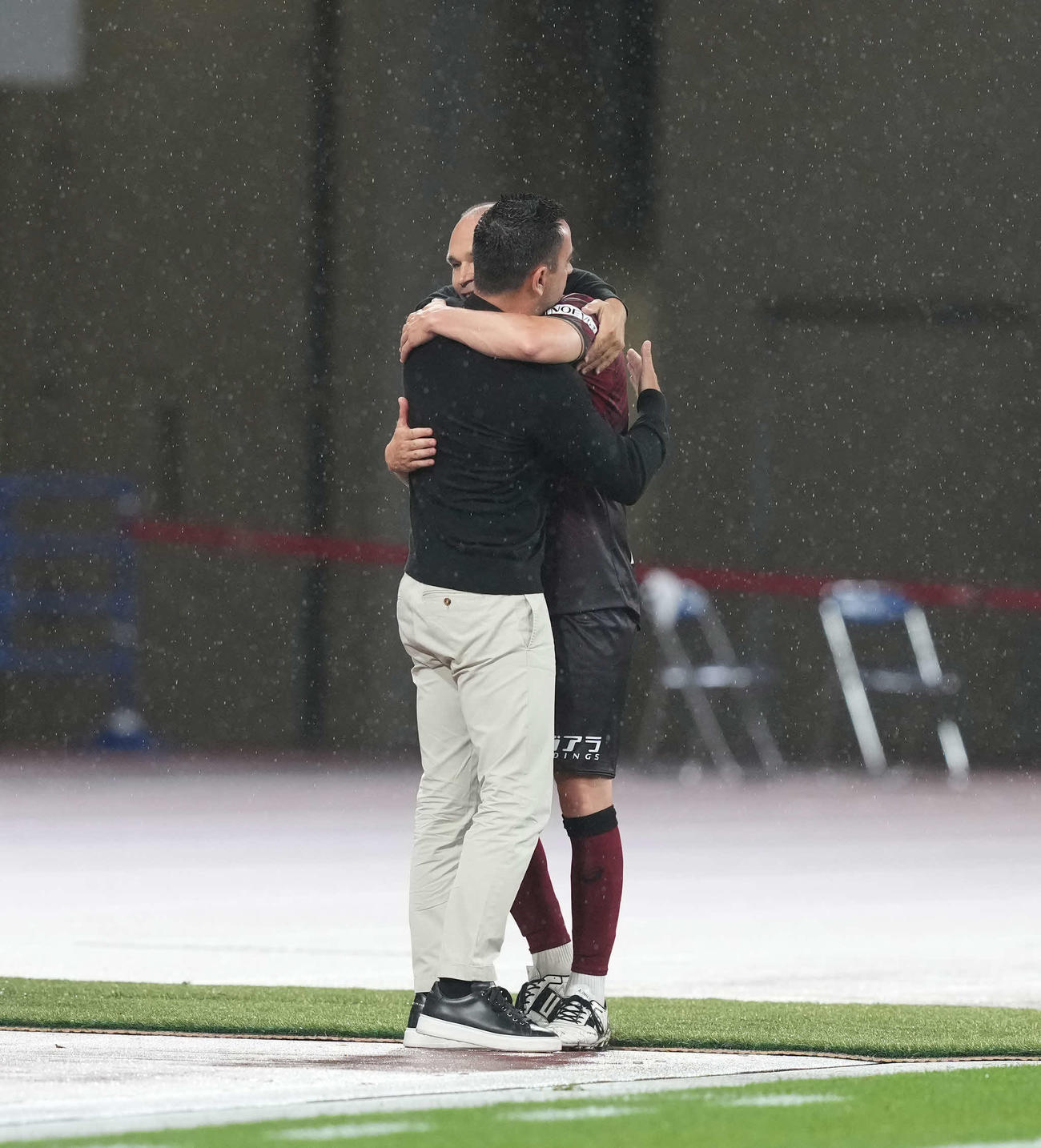 神戸対バルセロナ　後半、交代でピッチを後にした神戸イニエスタ（右）はバルセロナのシャビ監督と抱き合う（撮影・井上学）