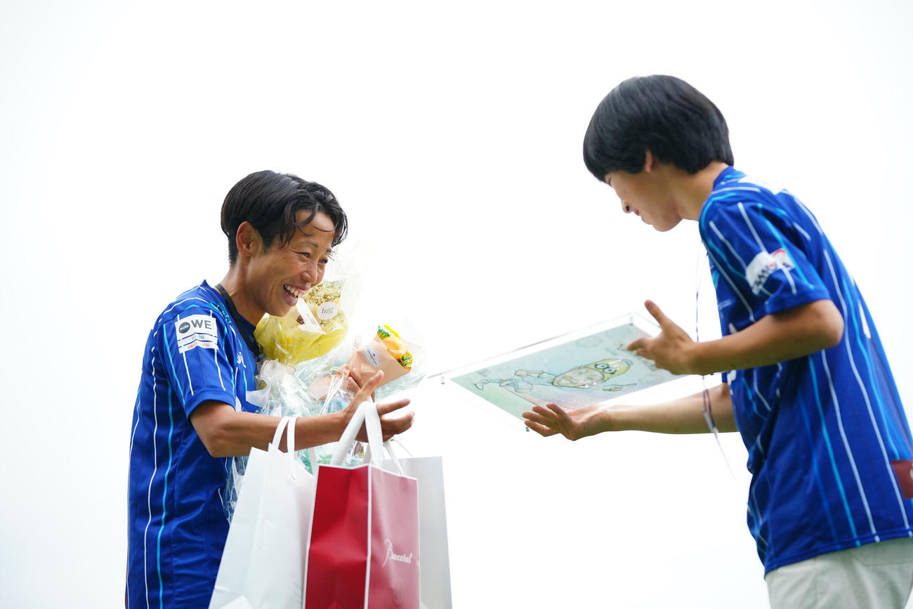 ちふれ埼玉対三菱重工浦和　試合後のセレモニーで家族たちから記念品を贈られ笑顔を見せるちふれ埼玉山本（左）（撮影・垰建太）