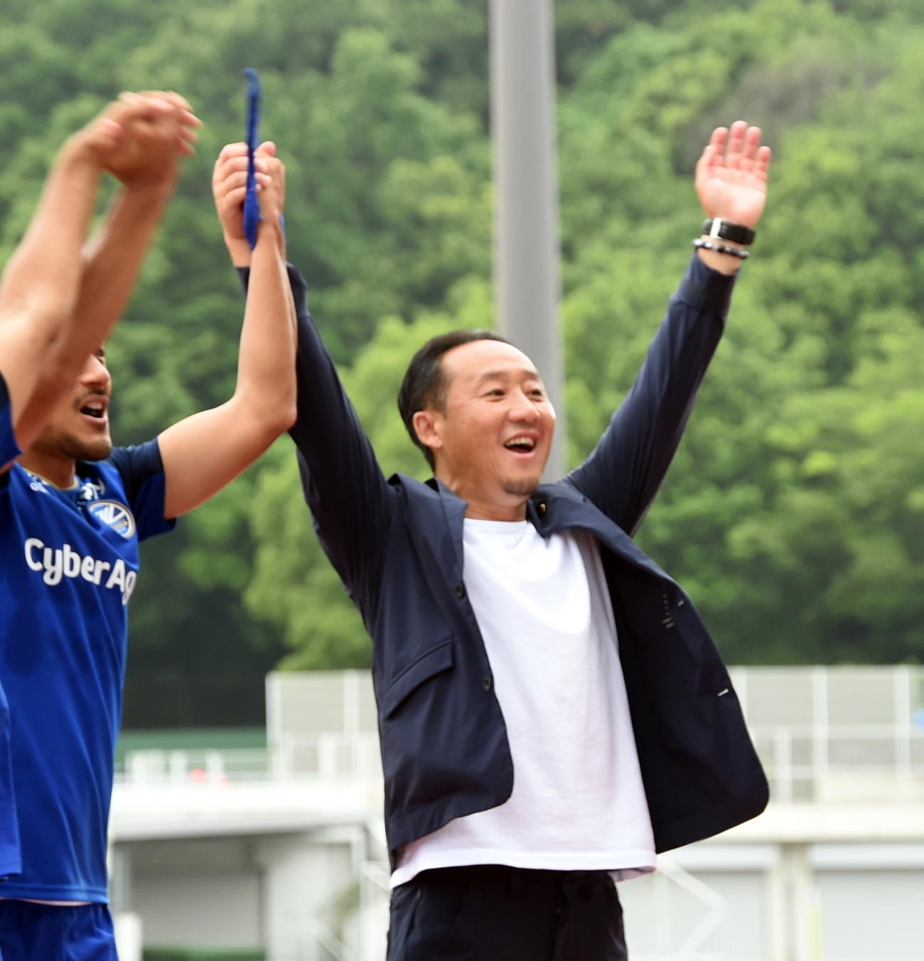 両手を挙げてサポーターと勝利の喜びを分かち合う町田黒田監督（右）