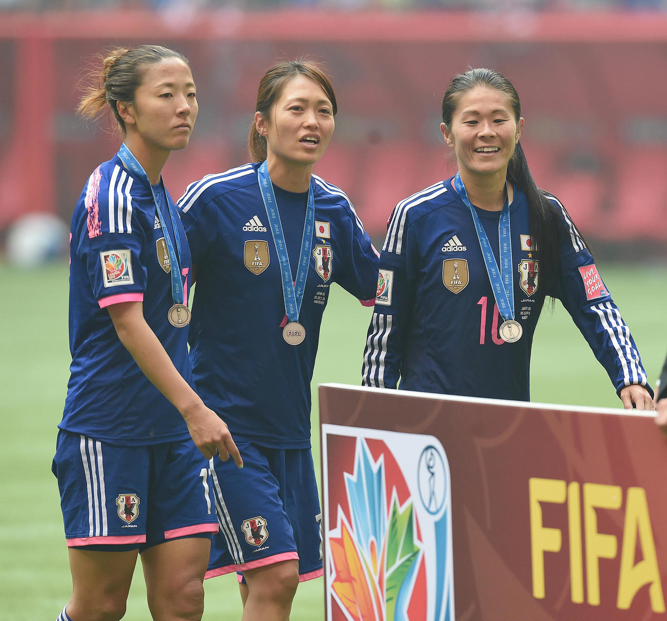 15年7月、女子W杯の表彰式で銀メダルを受け取り、大儀見優季（左）、安藤梢（中央）と引き揚げる澤穂希さん