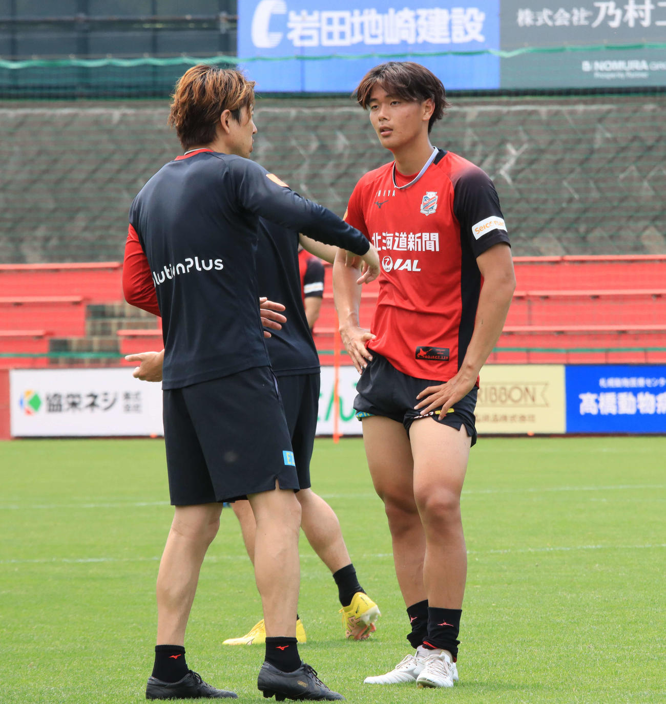 ルヴァン杯磐田戦前日練習後、杉浦コーチ（左）から指導を受ける札幌西野（撮影・保坂果那）