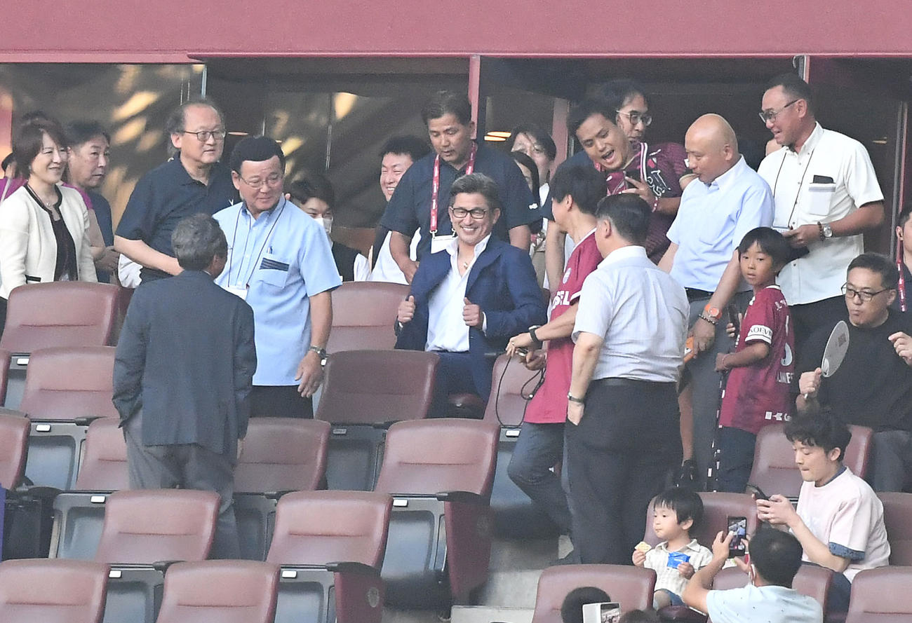 神戸対横浜FCを観戦のため席に着いた三浦知良（中央）はファンに囲まれる（撮影・滝沢美穂子）