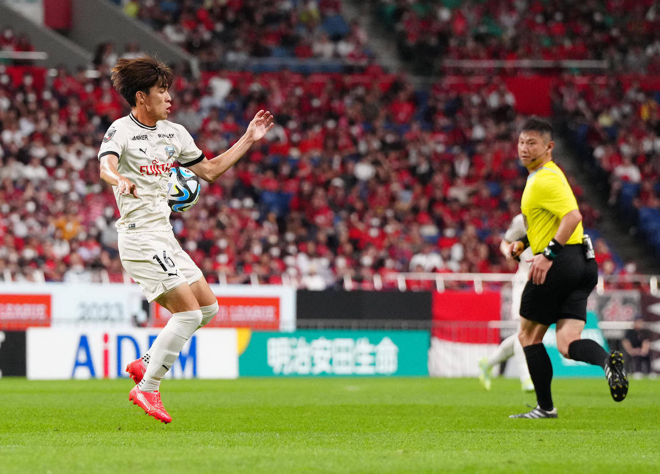 浦和対川崎F　後半、トラップする川崎F瀬古（左）。右は今村主審（撮影・江口和貴）