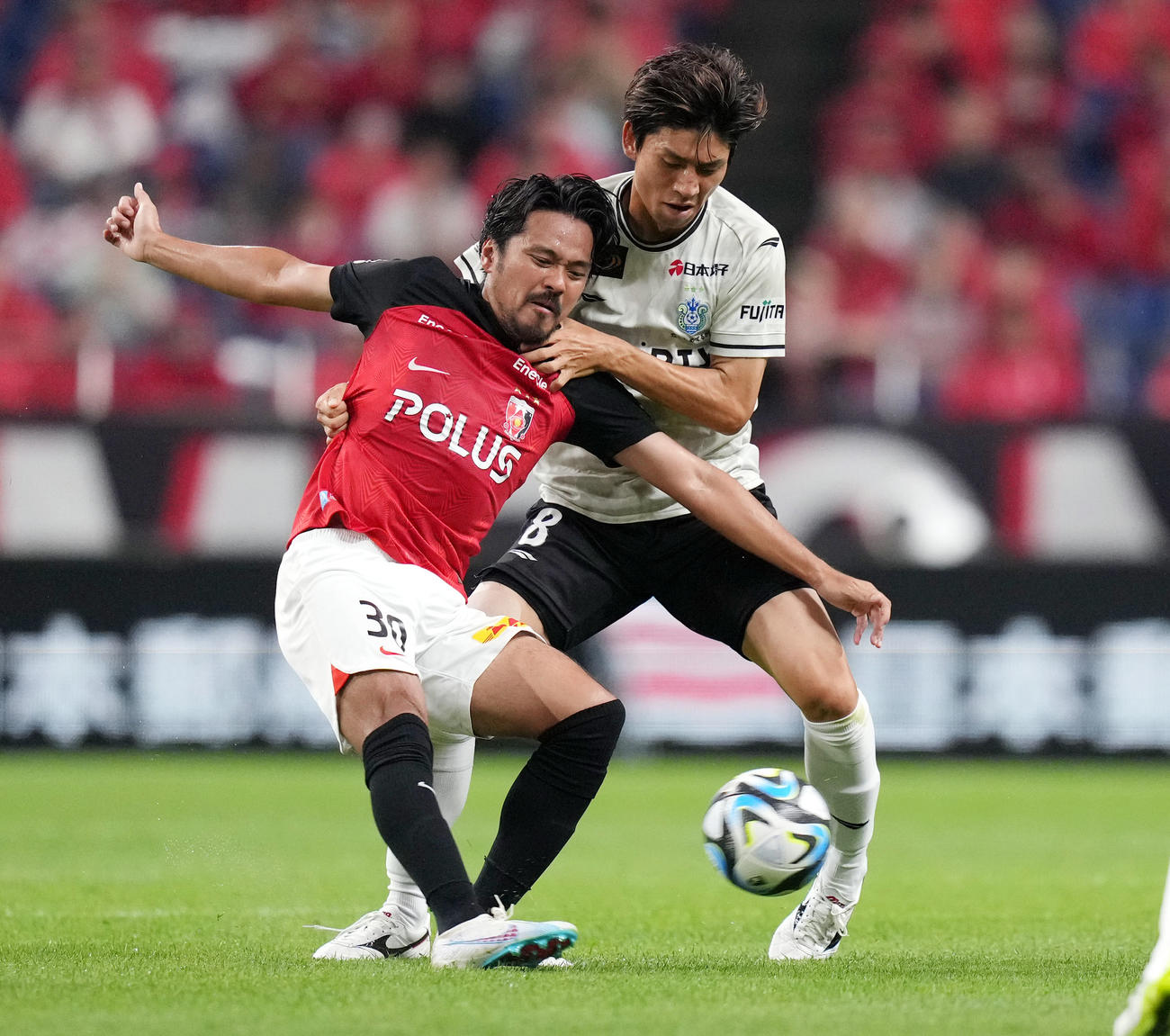 浦和対湘南　前半、湘南大野（右）のマークを受けながら、パスを出す浦和興梠（撮影・狩俣裕三）